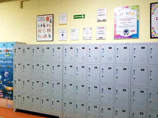 Fotografia przedstawia szafki na korytarzu szkolnym.