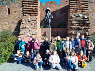 Uczestnicy wycieczki szkolnej przed pomnikiem Małego Żołnierza